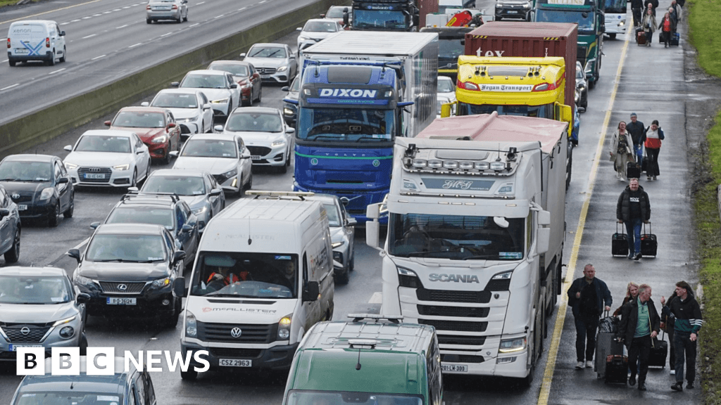 People walk along motorway towards Dublin Airport as fuel protests continue