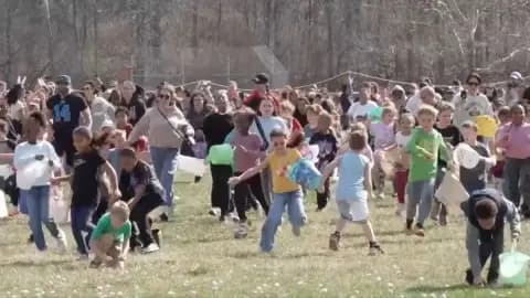 Children run across a grassy field covered in marshmallows