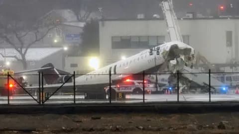 A damaged passenger plane lies on the runway of LaGuardia Airport as emergency vehicles surround it.