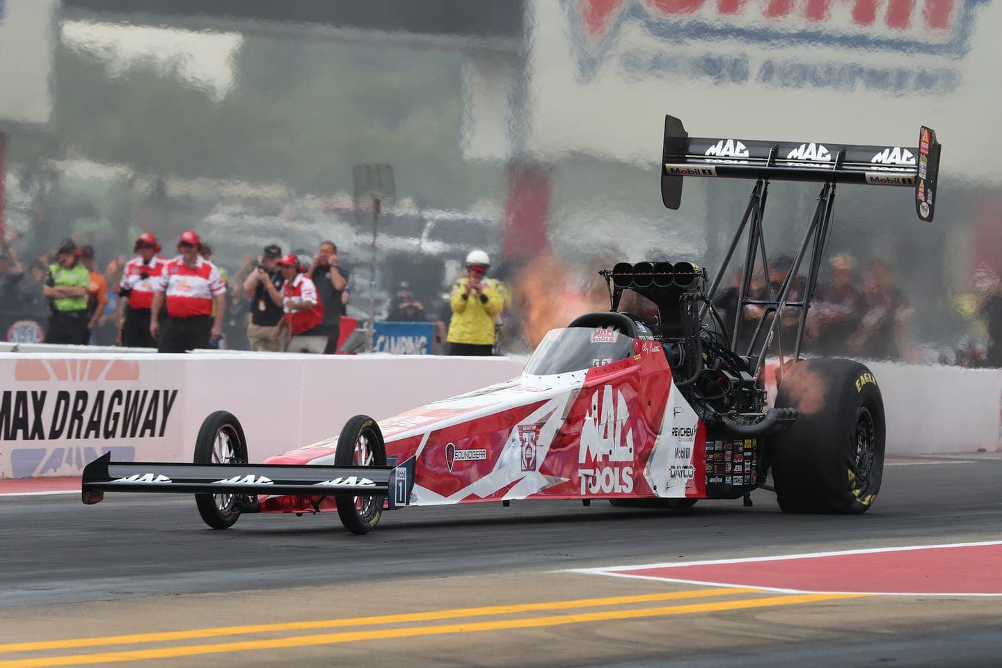 top fuel dragster launching off the starting line at a racing event