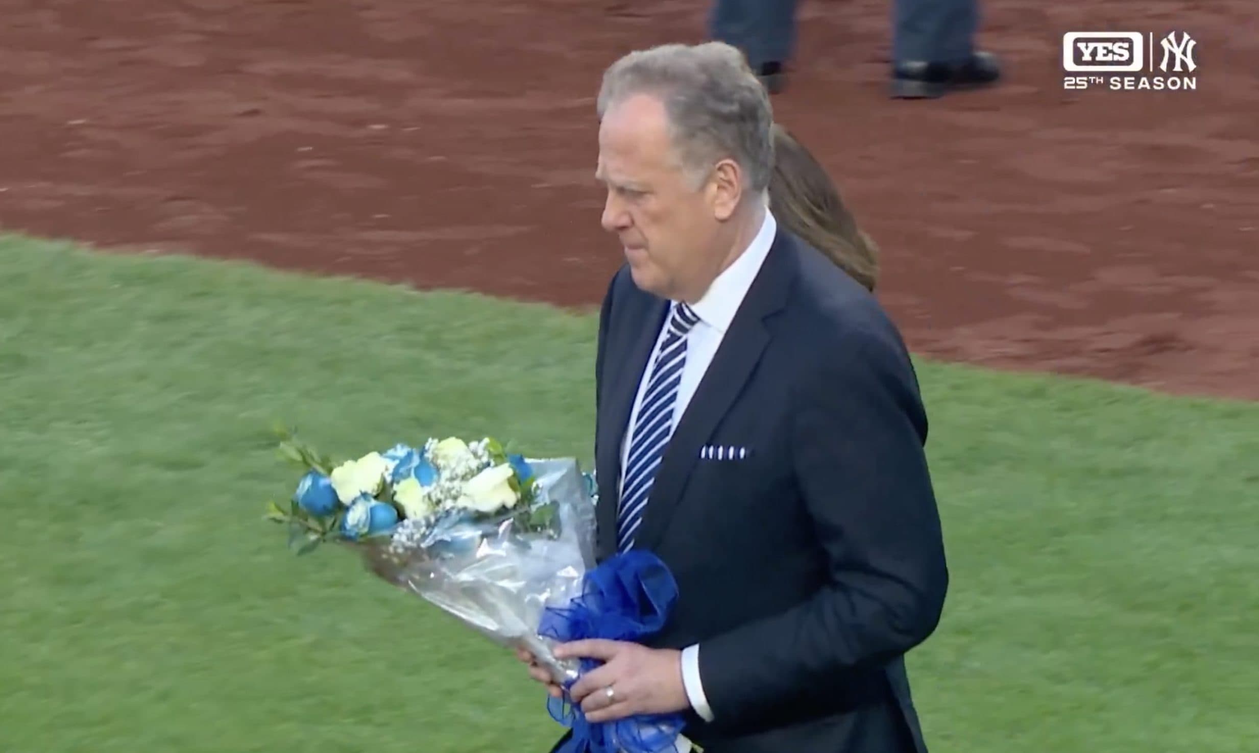 Michael Kay and Suzyn Waldman placed flowers on home plate in honor of New York Yankees radio legend John Sterling. Credit: YES Network