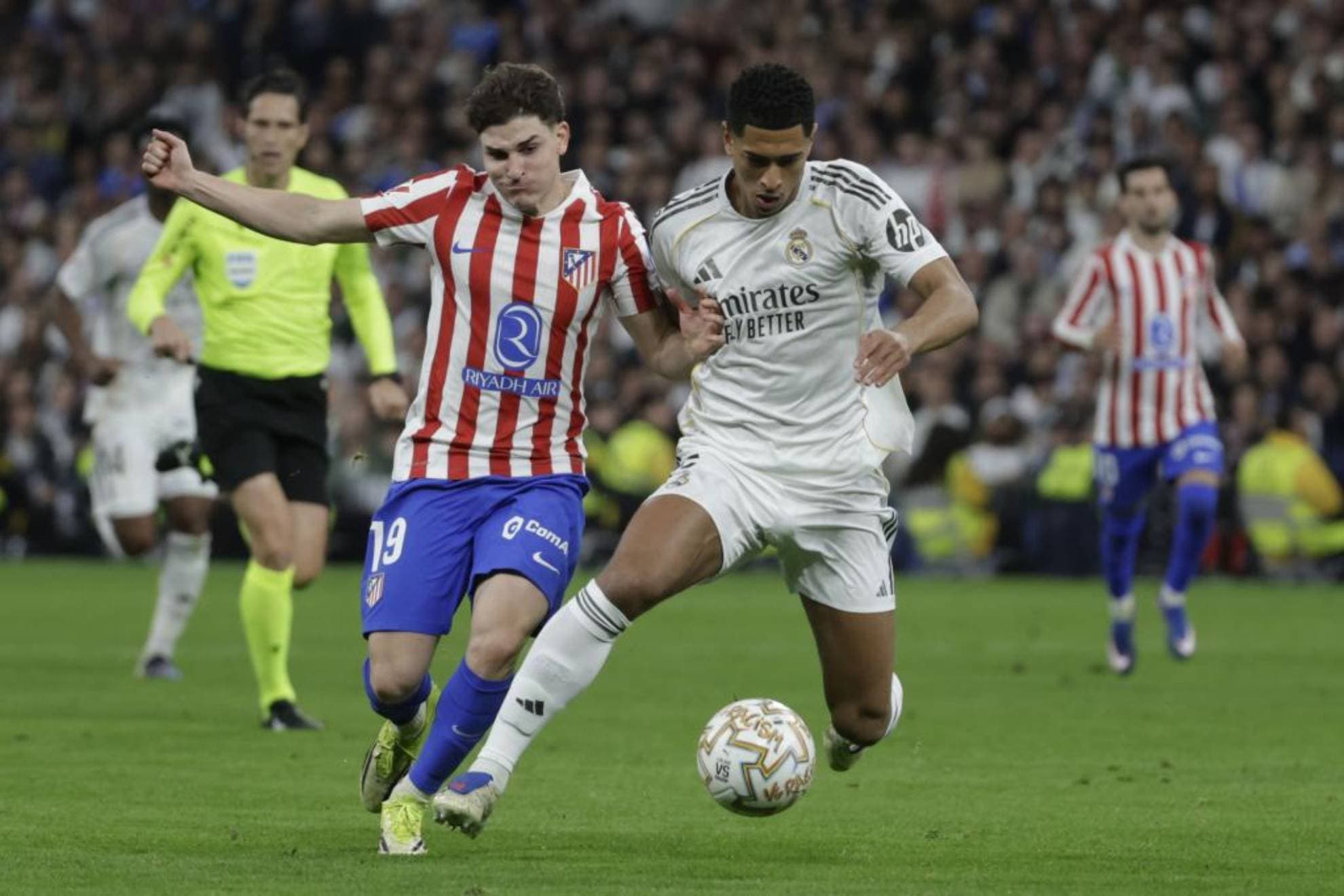 El centrocampista del Real Madrid Jude Bellingham (d) pelea un balón con Julián Álvarez, del Atlético, durante el partido de la jornada 29 de LaLiga que Real Madrid y Atlético de Madrid