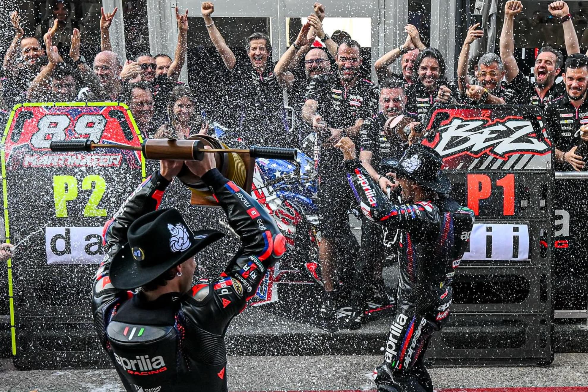 Rivola, al fondo, enfrente de Bezzecchi y Martín, en plena fiesta de Aprilia.