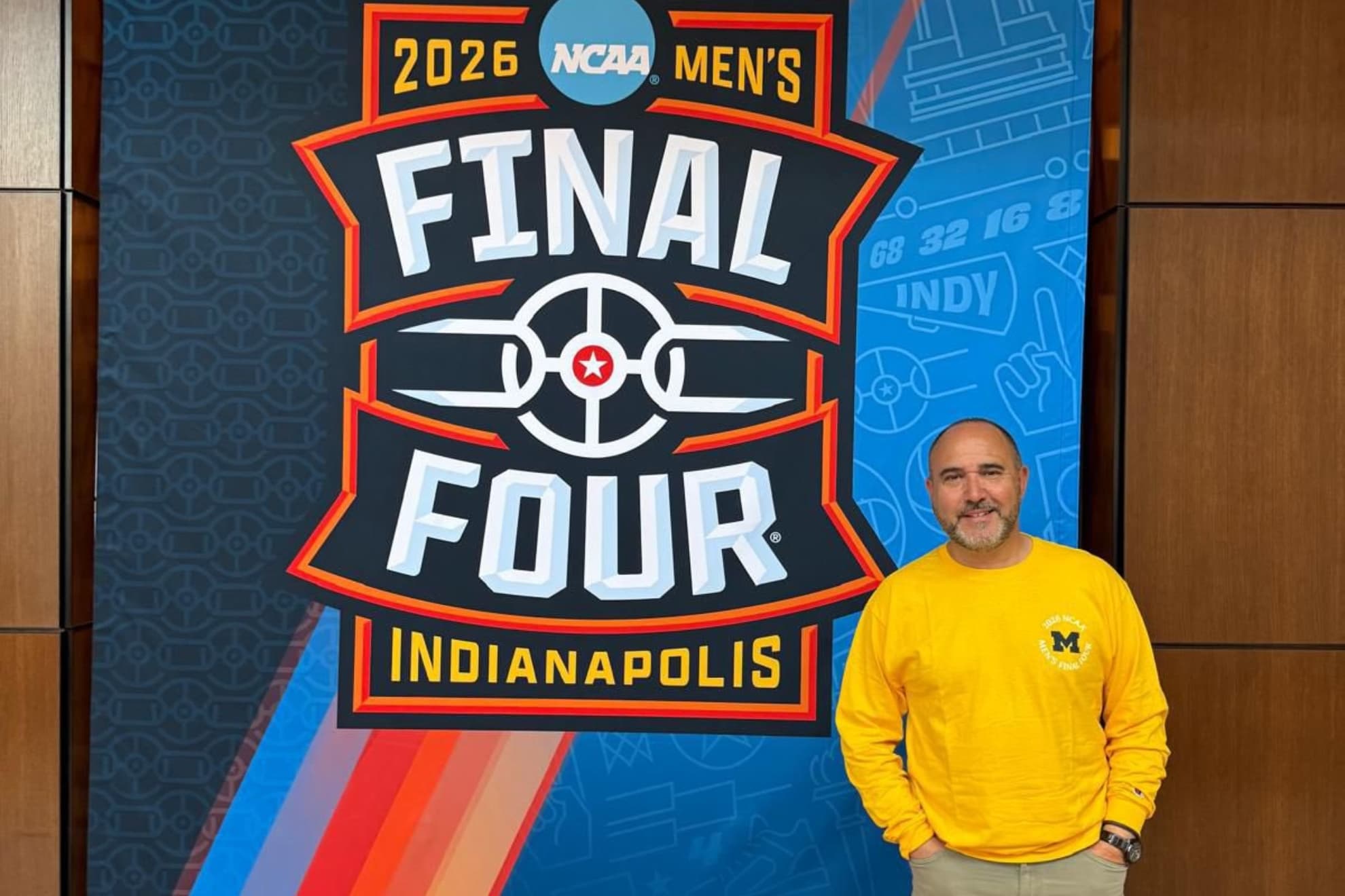 Mateo, junto a un cartel de la F4 con la sudadera de los Wolverines de Michigan.