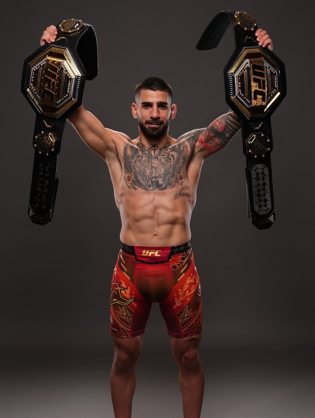 Ilia Topuria posa con sus dos títulos de campeón de UFC.