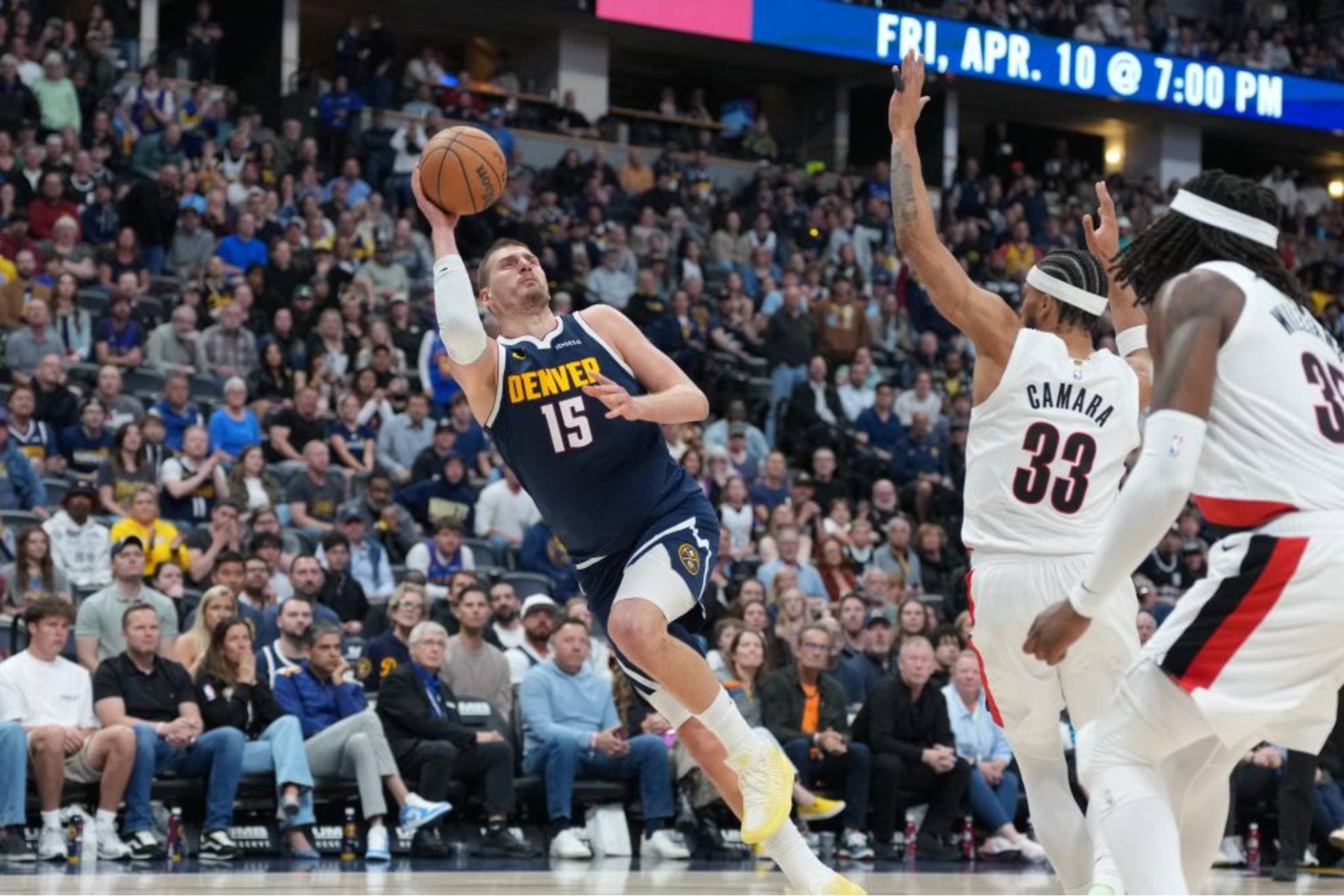 Nikola Jokic lanza en posición acrobática en el partido ante los Blazers.