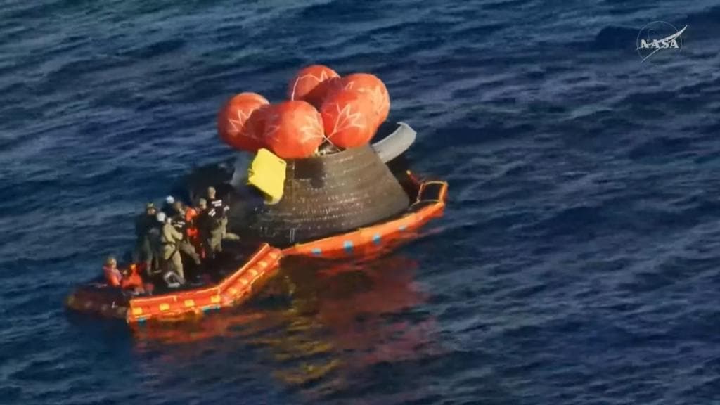 Captura de imagen de una transmisión de la NASA de tripulantes de Artemis II saliendo de la capsula Orión.