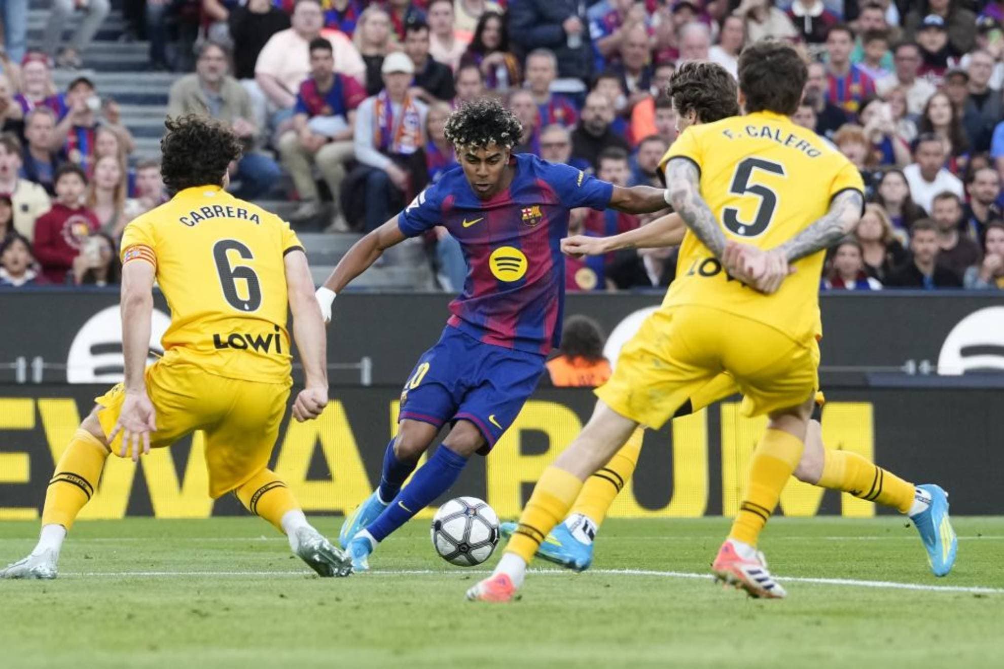 Lamine Yamal rodeado de jugadores del Espanyol en el partido de la jornada retro de LaLiga.
