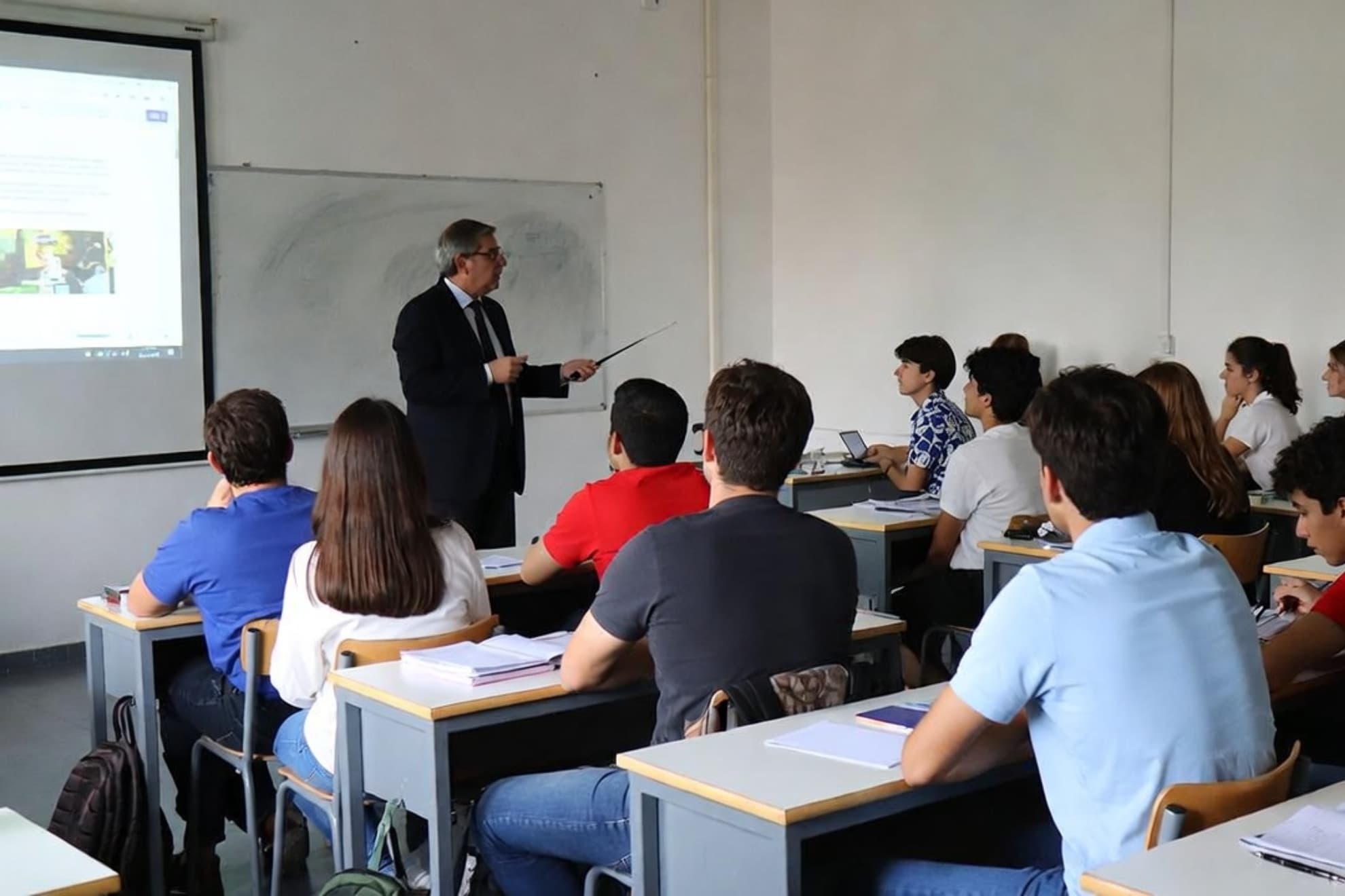 Imagen de recurso de un profesor dando clase en un aula.