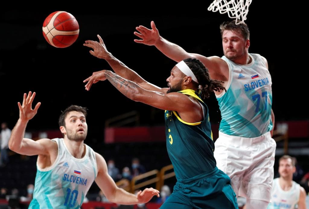 Patty Mills pasa el balón ante la defensa de Luka Doncic en los JJOO de Tokyo 2020.