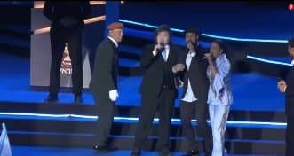 Momento en que Milei se sube al estrado para cantar.