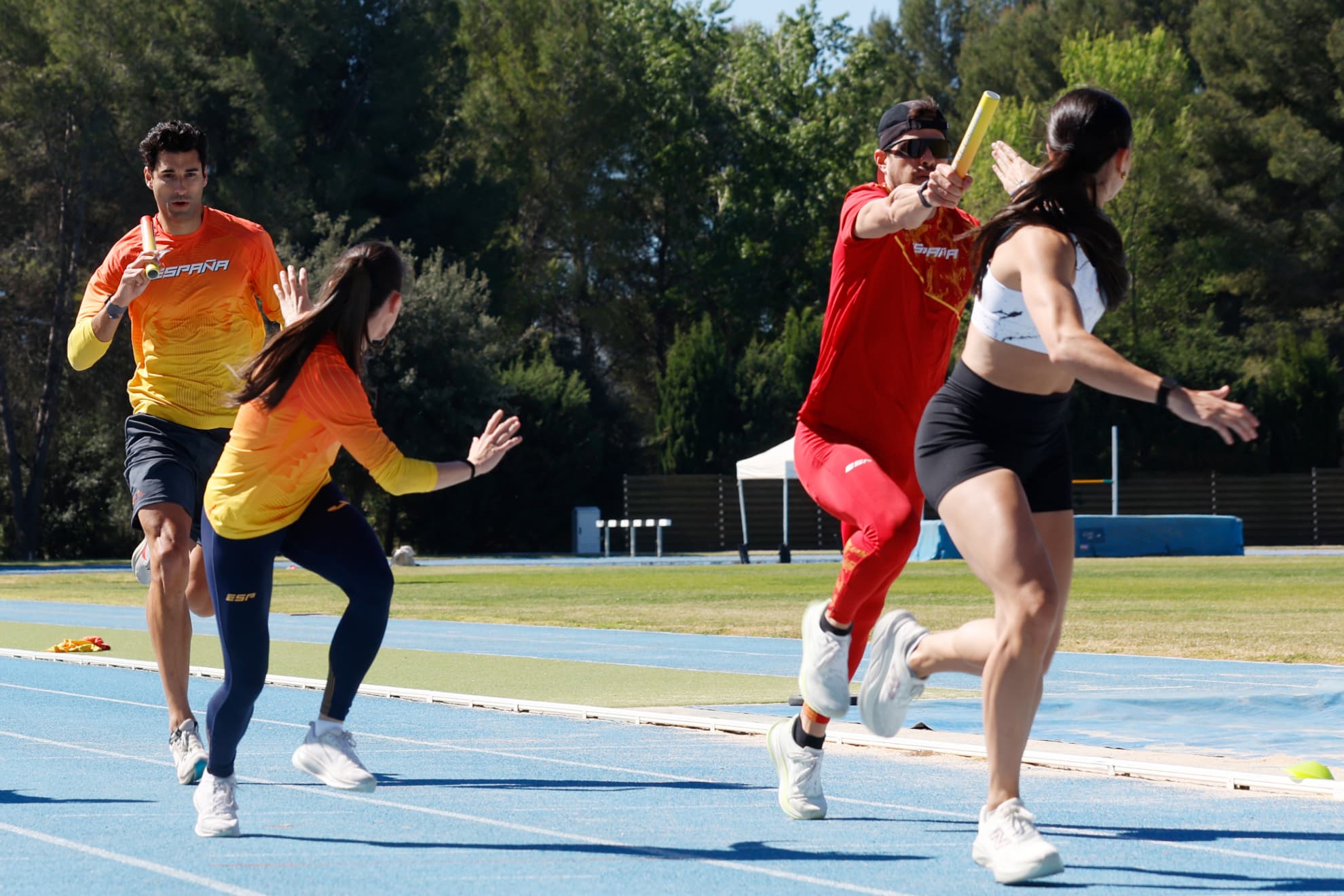 Óscar Husillos y Samu García, dos los 'Spanish Beatles' originales, entregan el testigo a Eva Santidrián y Paula Sevilla durante un entrenamiento del 4x400 mixto.