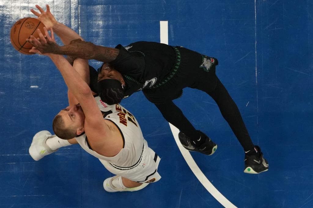 Jokic y McDaniels luchan un rebote en una acción del partido.