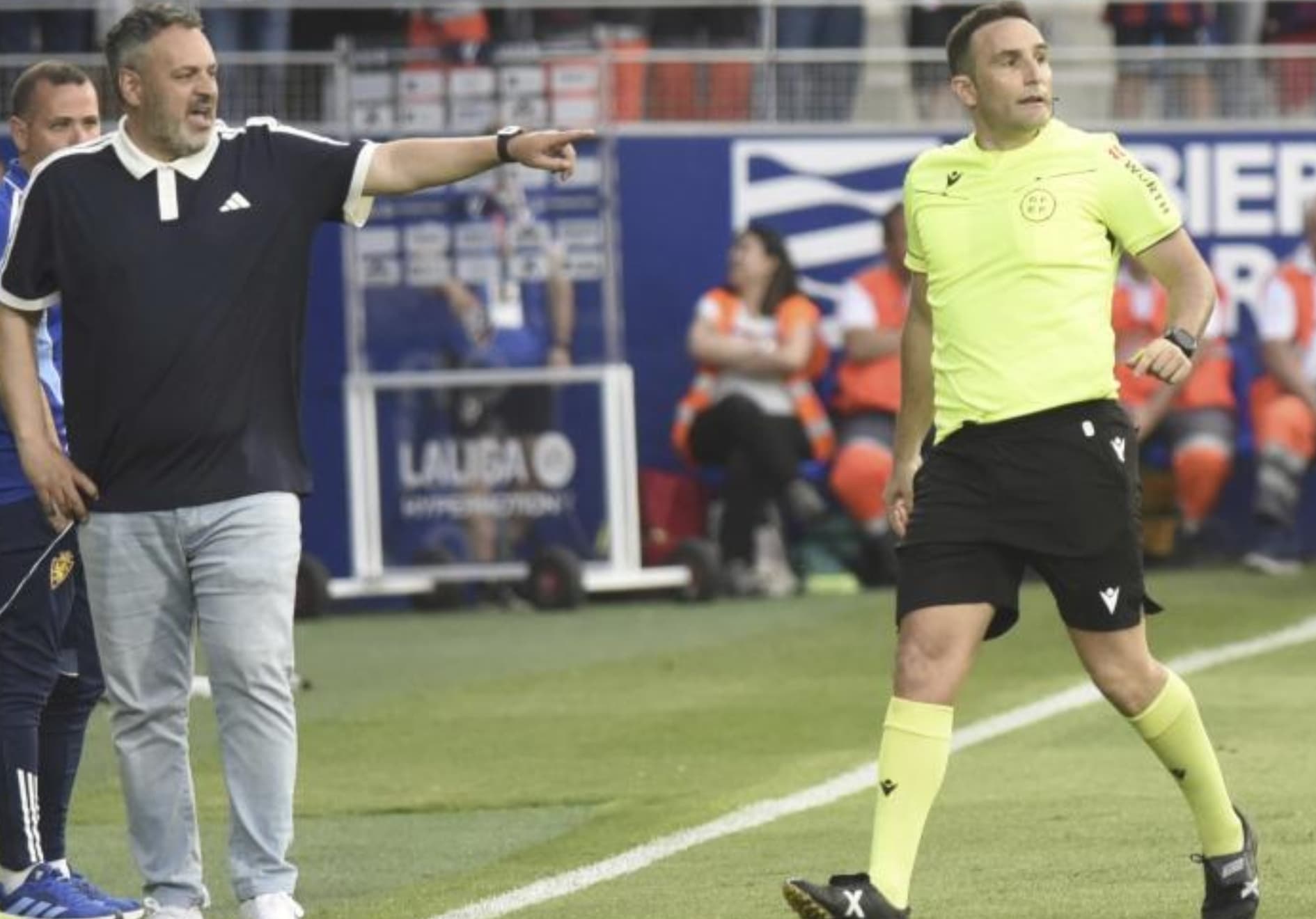 Dámaso Arcediano, en el partido Huesca-Zaragoza, pasa cerca del área técnica de David Navarro