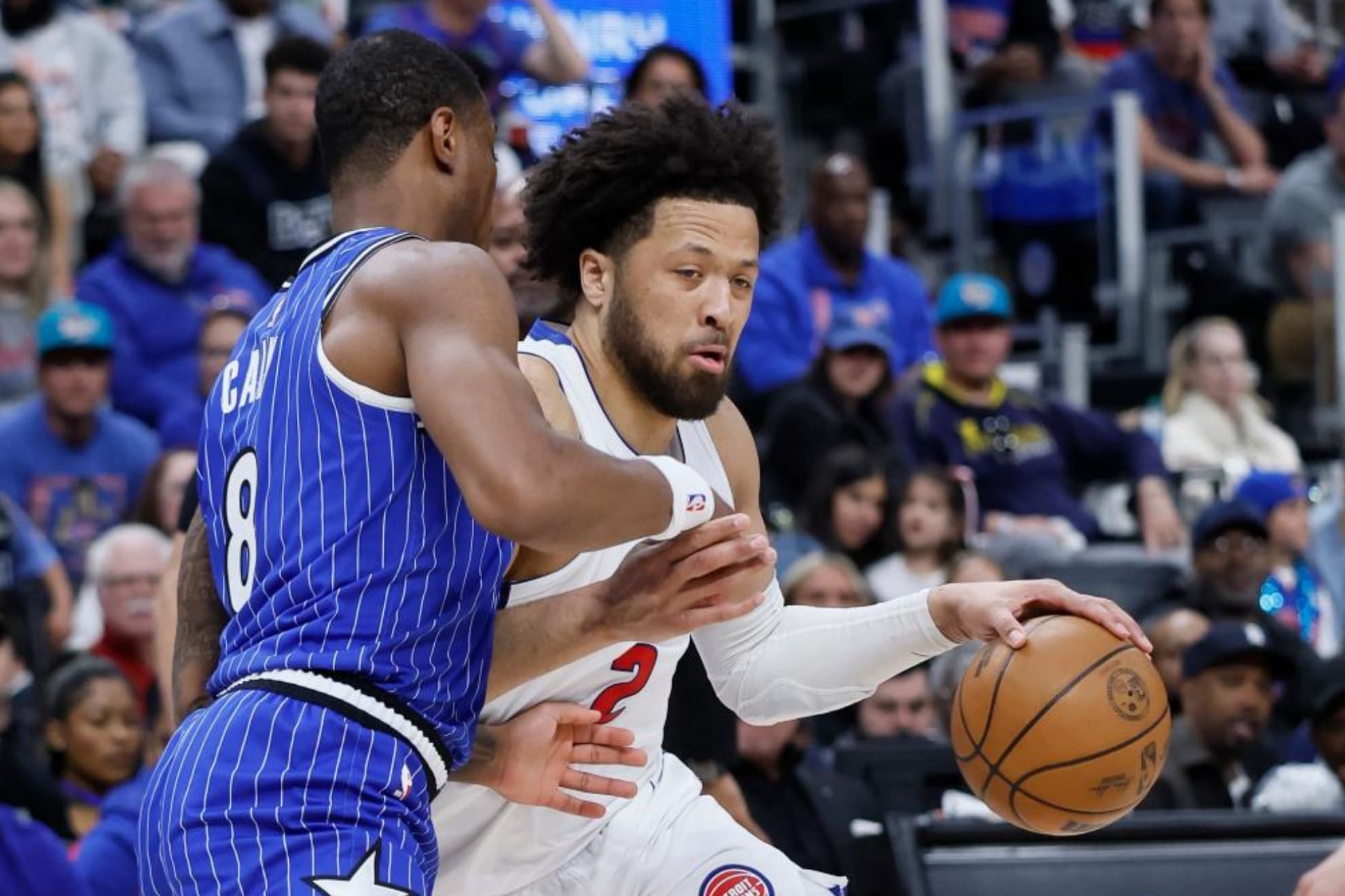 Cade Cunningham bota el balón ante la defensa de Jamal Cain.
