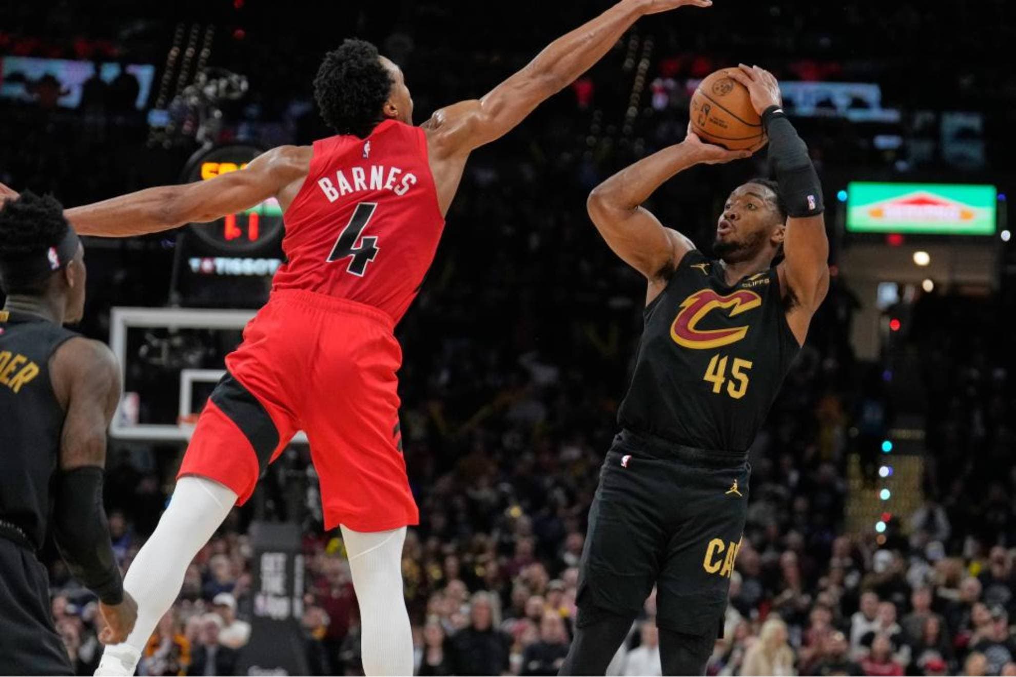 Donovan Mitchell lanza ante el intento de tapón de Scottie Barnes.