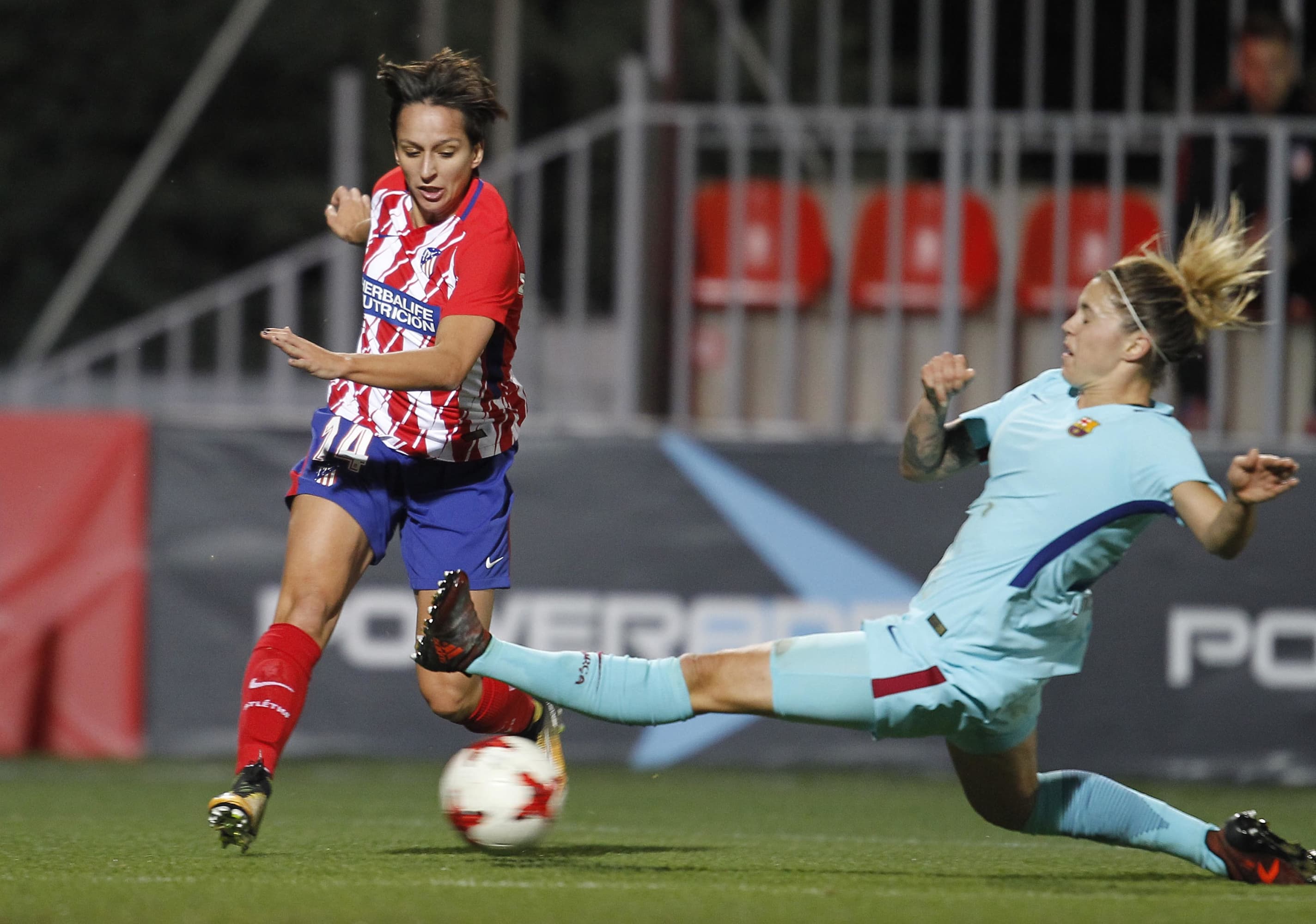 Marta Corredera, con el Atlético, evita una entrada de Mapi León, con el Barcelona.