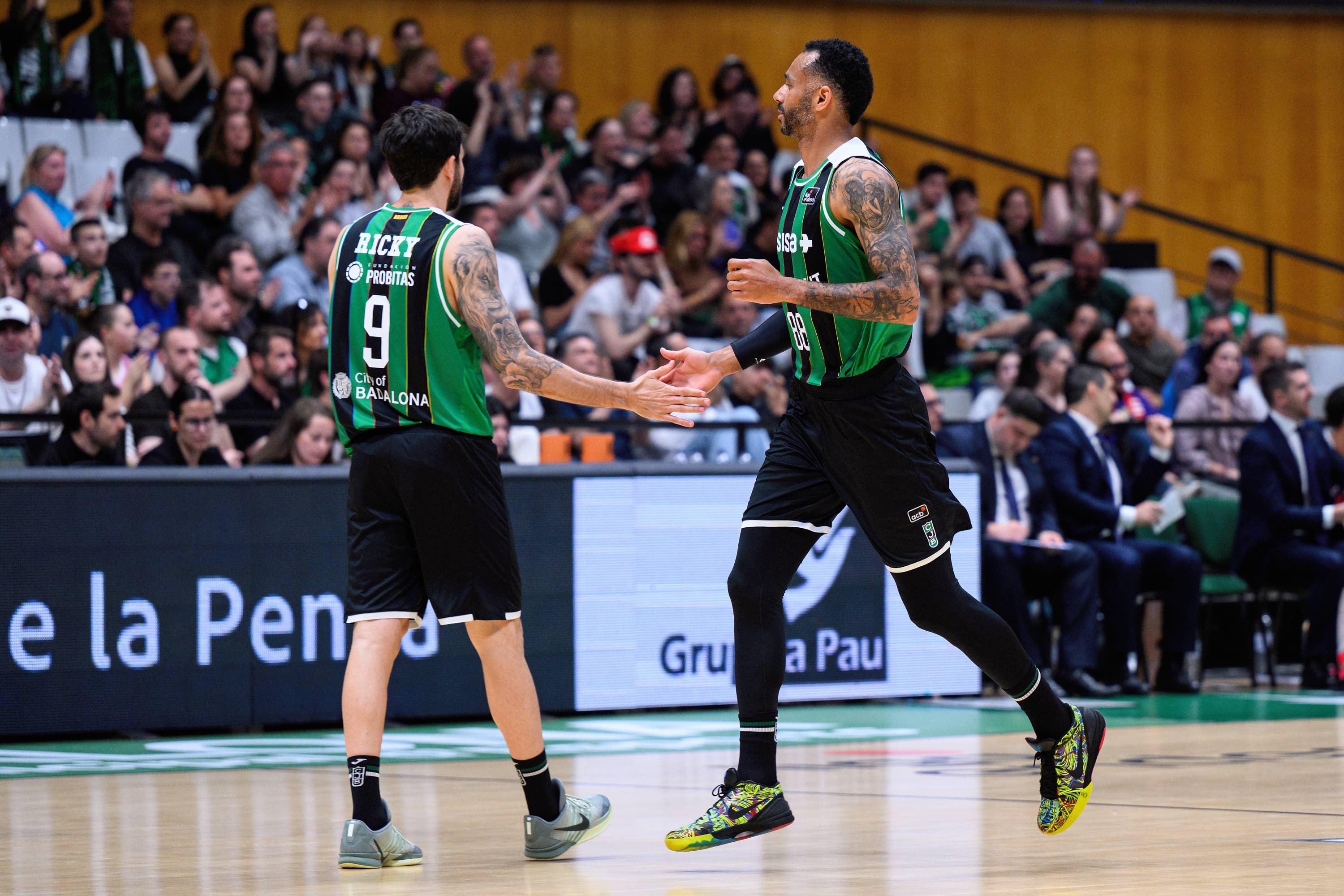 Hanga choca la mano con Ricky Rubio, su compañero en el Joventut de Badalona.