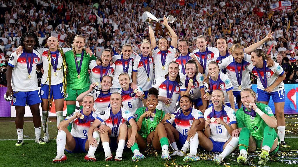 England players celebrate with the trophy in front of the travelling fans