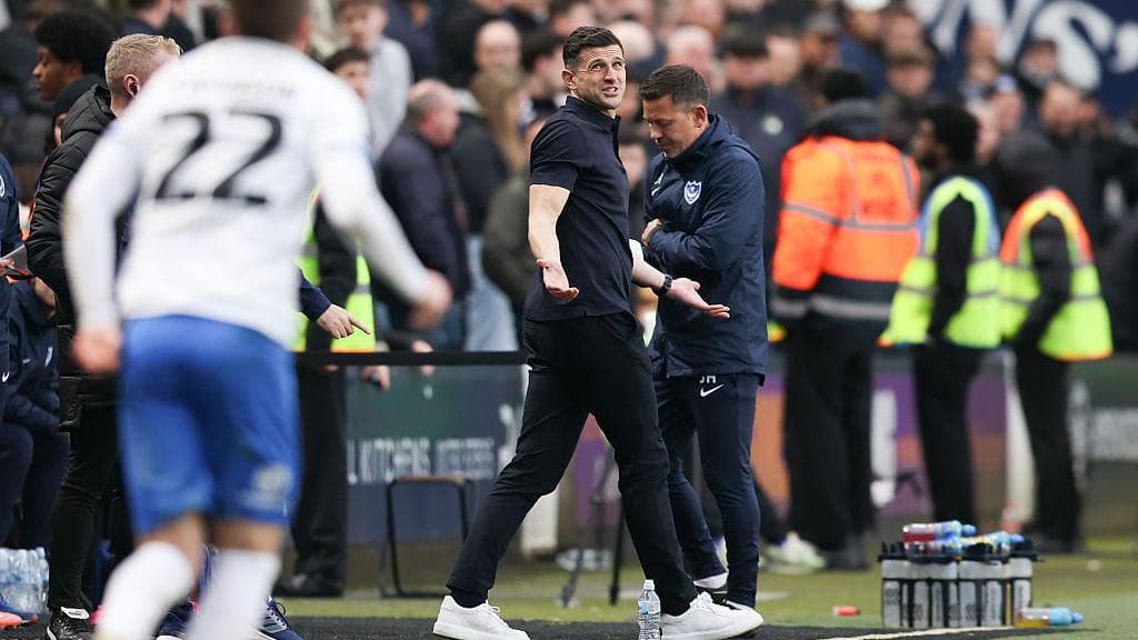 John Mousinho motions with his arms while looking upwards