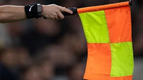 An assistant referee holds out a flag for offside
