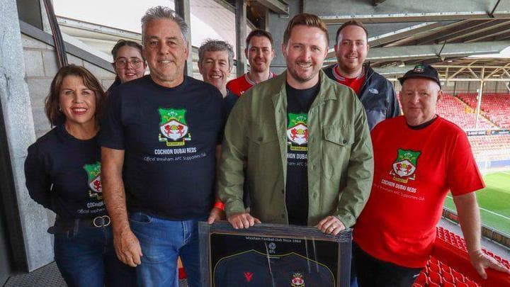 Fans smile inside the Racecourse football ground