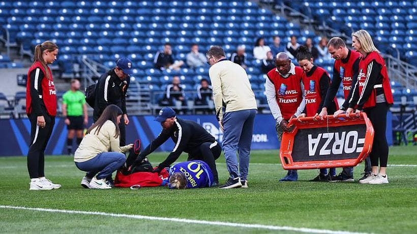 Jess Fishlock is treated on the pitch during Reign's game against Utah Royals