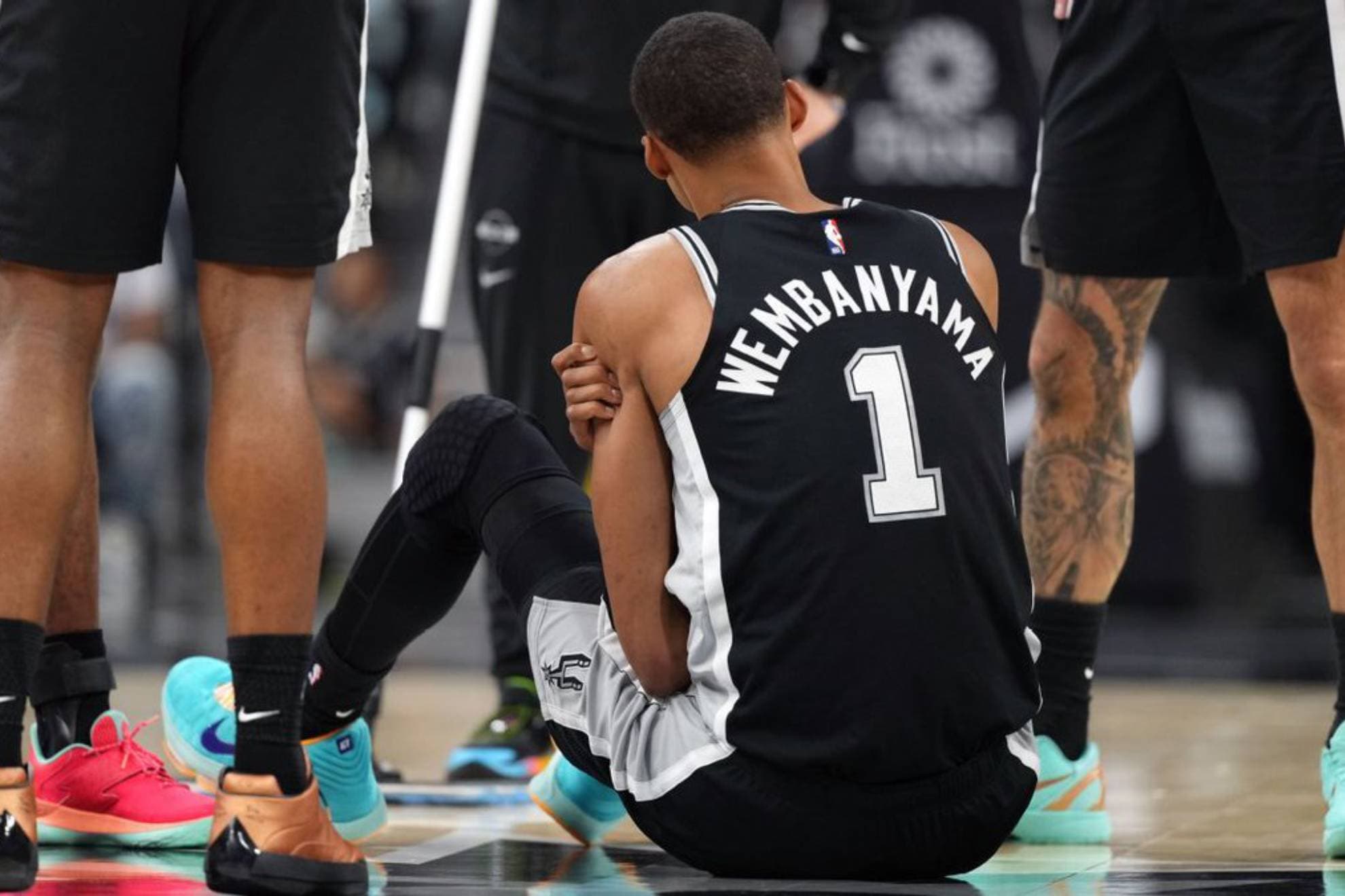 Victor Wembanyama, sentado en el suelo, se lamenta tras recibir un golpe en las costillas.