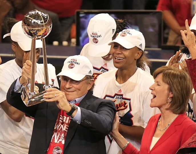 Fever owner Herb Simon gets a look at the WNBA trophy with standout Tamika Catchings, center, and team COO Kelly Krauskopf after an 87-78 win over the Lynx. The Indiana Fever hosted the Minnesota Lynx in game four of the WNBA Finals at Bankers Live Fieldhouse.